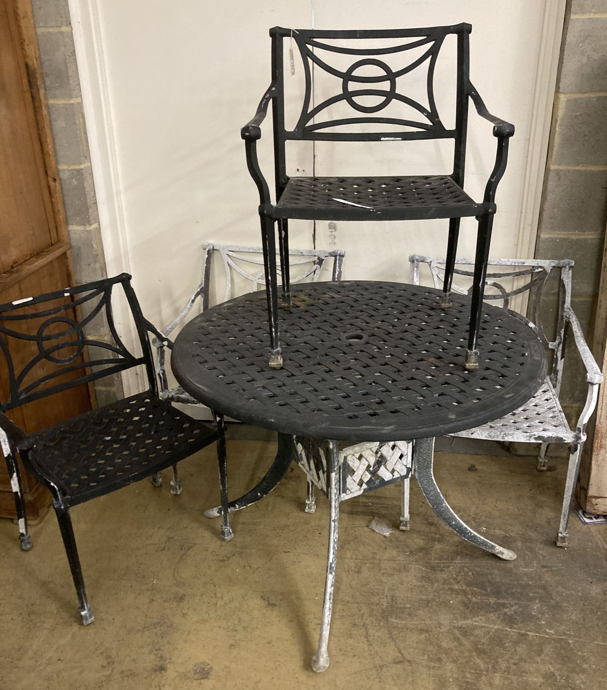 A painted aluminium circular garden table, 106cm diameter together with four matching elbow chairs